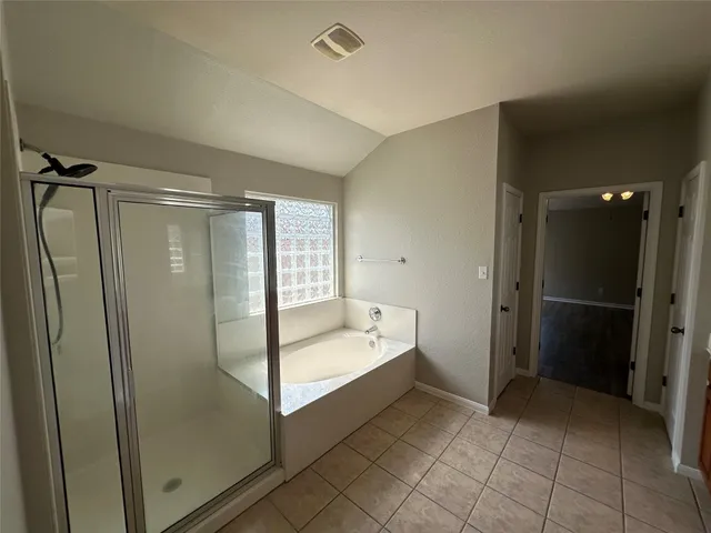 a spacious bathroom with a bathtub and a shower