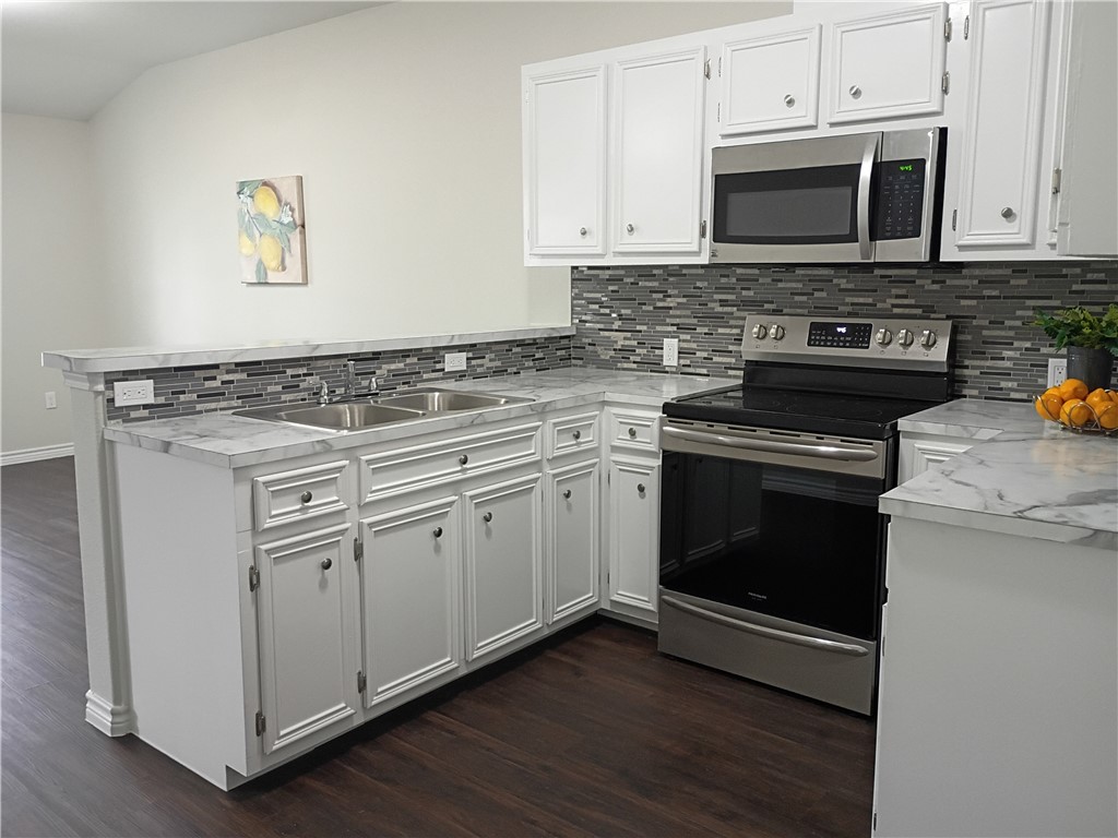 1652 16th Street Corpus Christi, TX 78404 - Photo 7 of 19 a kitchen with granite countertop cabinets stainless steel appliances and wooden floor