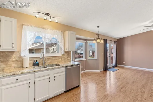 a kitchen with granite countertop a sink cabinets and wooden floor