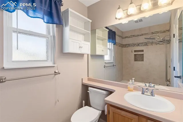 a bathroom with a sink a toilet and mirror