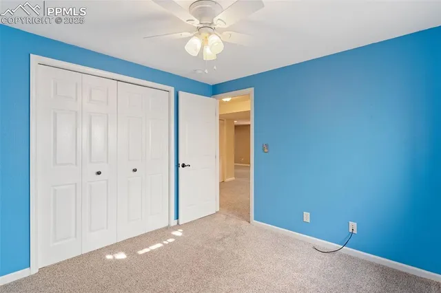 a view of an empty room and chandelier fan