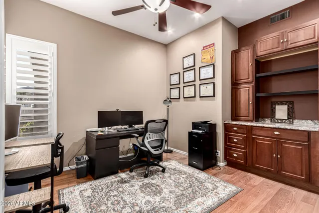 a view of a workspace with furniture and a window
