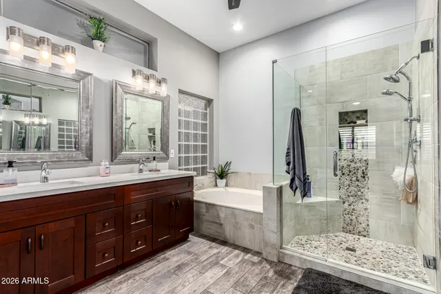 a spacious bathroom with a double vanity sink mirror and shower