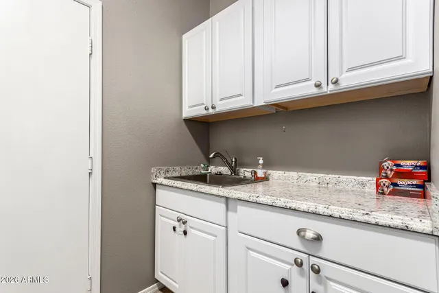 a kitchen with granite countertop white cabinets and a sink