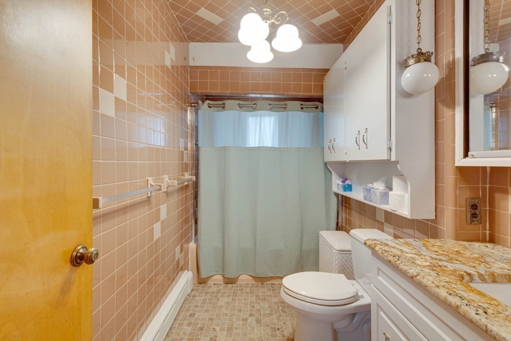 45 Jackson Road Somerville, MA 02145 - Photo 11 of 27 a bathroom with a granite countertop toilet sink and mirror