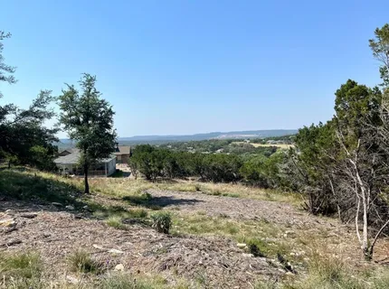 an aerial view of residential house with outdoor space and trees all around