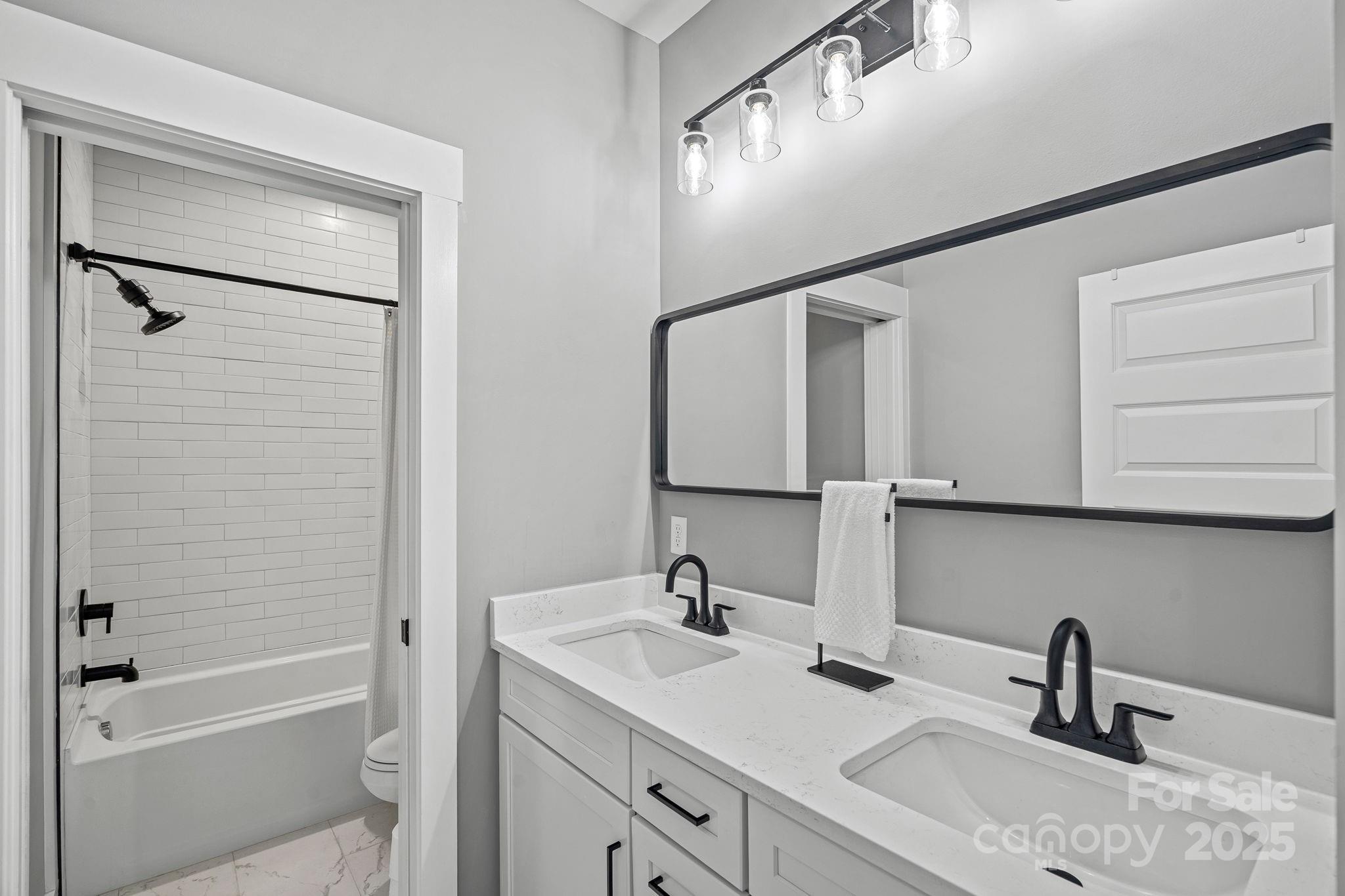20615 Rio Oro Drive Cornelius, NC 28031 - Photo 24 of 40 a bathroom with a double vanity sink a mirror and a bathtub