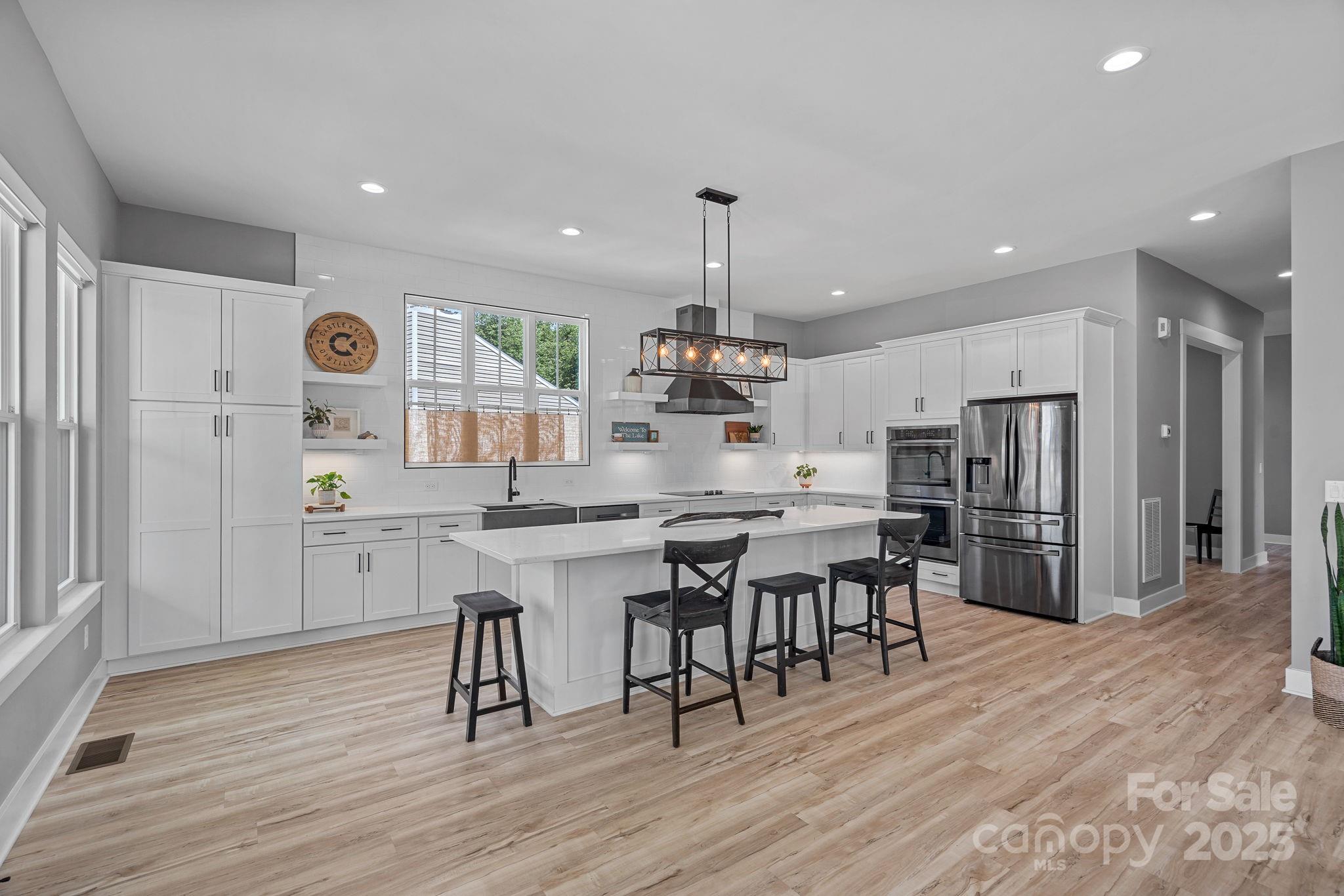 20615 Rio Oro Drive Cornelius, NC 28031 - Photo 8 of 40 a kitchen with stainless steel appliances a dining table chairs stove refrigerator and cabinets