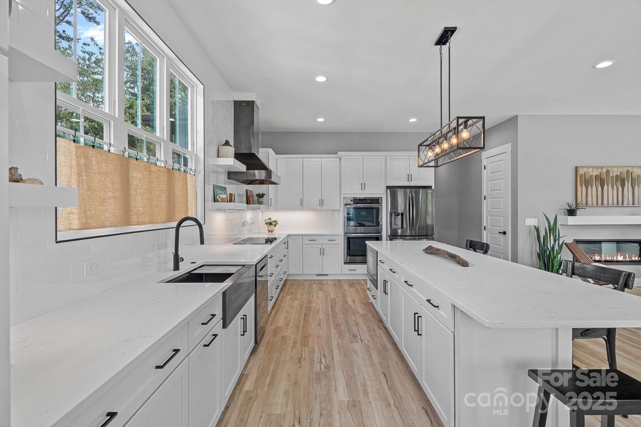 20615 Rio Oro Drive Cornelius, NC 28031 - Photo 9 of 40 a large kitchen with kitchen island a large counter space a sink appliances and cabinets