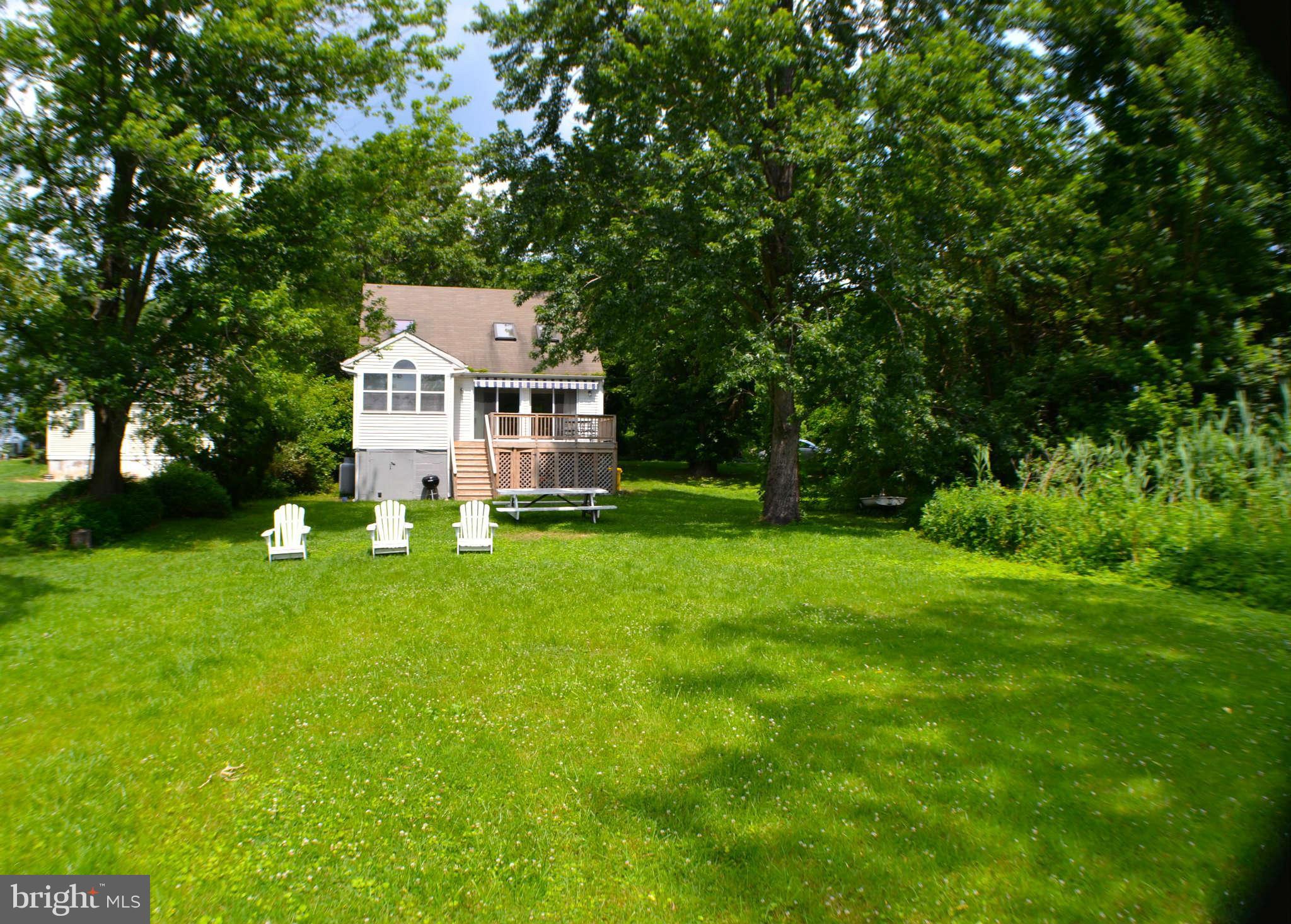 392 Riverside Drive Pasadena, MD 21122 - Photo 4 of 30 a front view of a house with a yard and trees