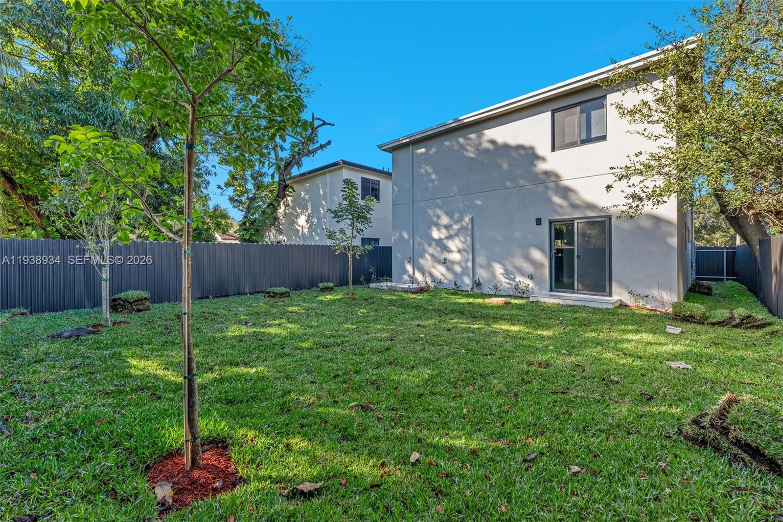5821 Northwest 30th Avenue Miami, FL 33142 - Photo 11 of 14 a backyard of a house with plants and large tree