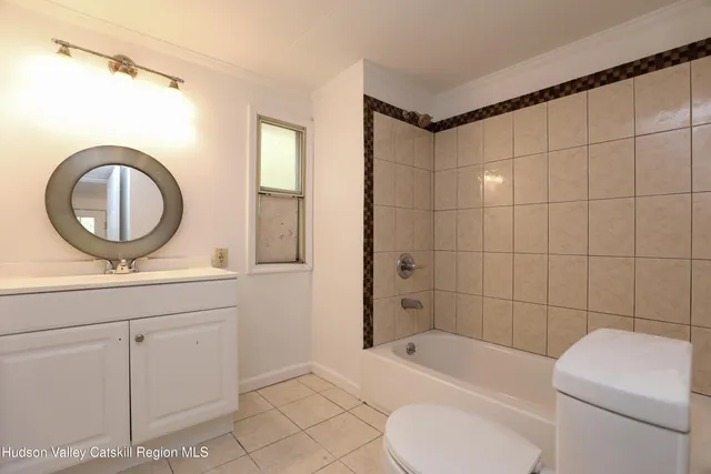 a bathroom with a toilet sink a mirror and vanity