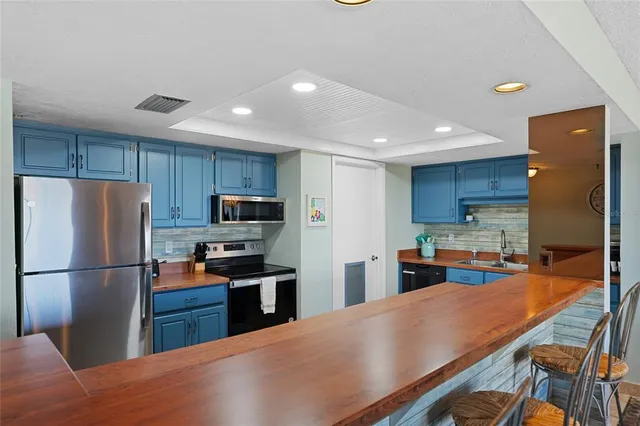 a kitchen with stainless steel appliances granite countertop a refrigerator stove microwave sink and cabinets