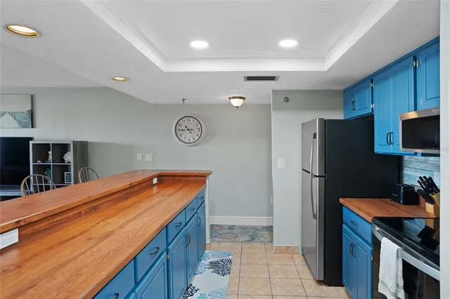 a room with stainless steel appliances kitchen island a refrigerator sink and stove