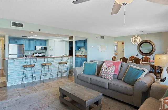 a living room with furniture a rug and kitchen view