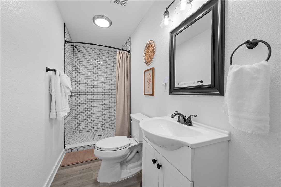 621 South 9th Street Waco, TX 76706 - Photo 21 of 31 a bathroom with a toilet a sink a mirror and shower