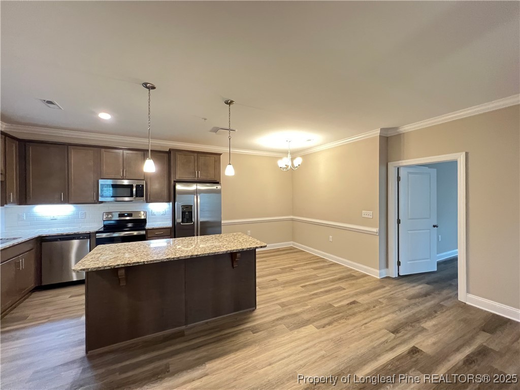 260 Gallery Drive, Unit 101 Spring Lake, NC 28390 - Photo 12 of 31 a large kitchen with stainless steel appliances a large counter top and wooden floor