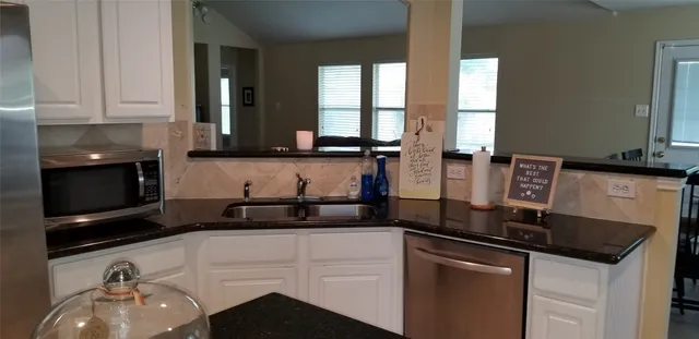 a kitchen with stainless steel appliances granite countertop a sink stove and cabinets