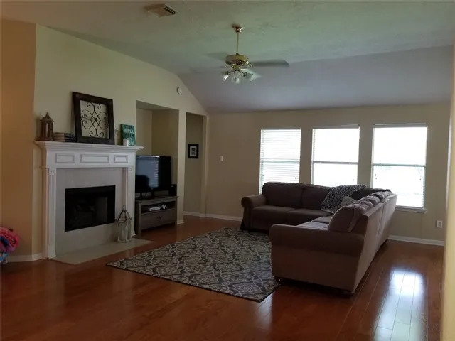 a living room with furniture and wooden floor