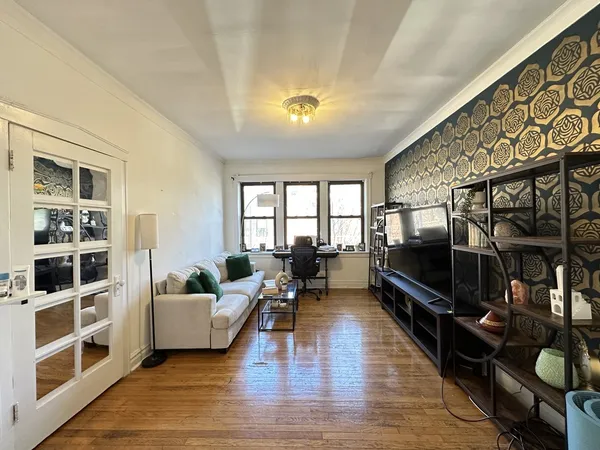 a living room with furniture a flat screen tv and a floor to ceiling window