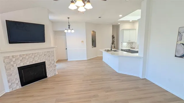 a large kitchen with a fireplace and a flat screen tv