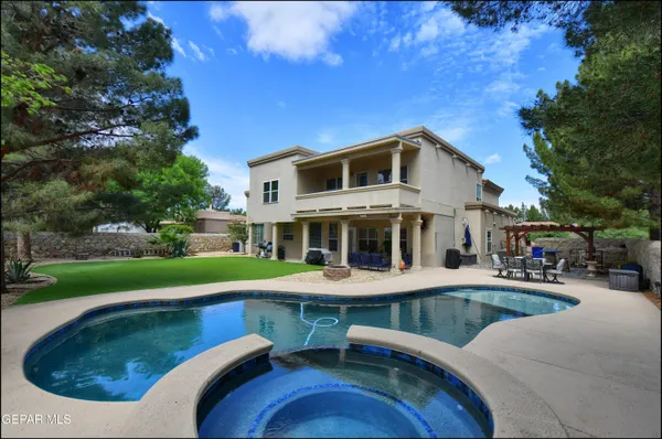 a view of a house with swimming pool and sitting area