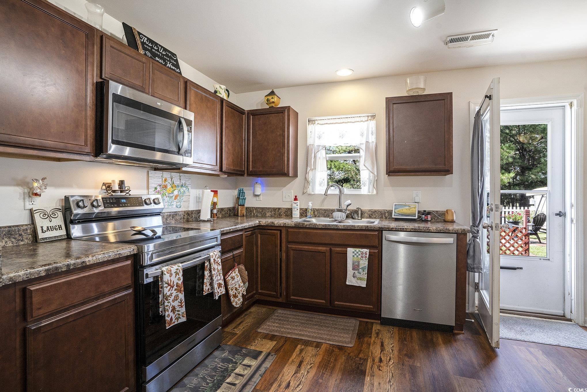763 Trap Shooter Circle Longs, SC 29568 - Photo 12 of 37 Kitchen featuring stainless steel appliances, dark countertops, dark wood finished floors, dark brown cabinets, and recessed lighting