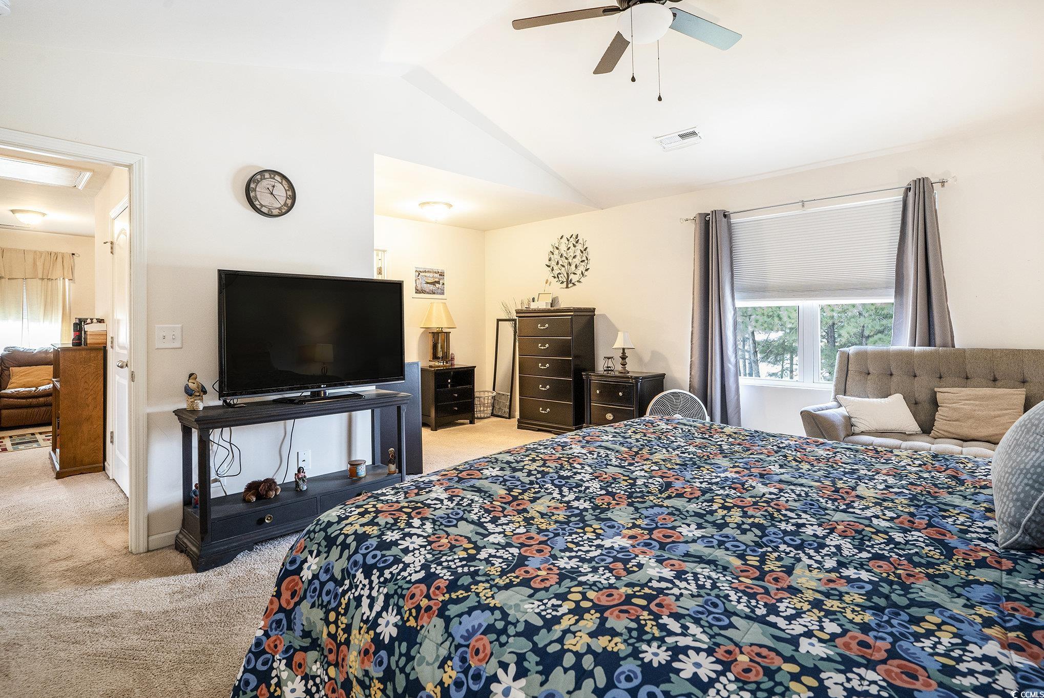 763 Trap Shooter Circle Longs, SC 29568 - Photo 17 of 37 Bedroom with light colored carpet, lofted ceiling, and a ceiling fan