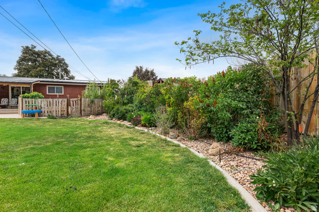 523 South Main Street Payson, UT 84651 - Photo 41 of 41 Expansive green lawn with a landscaped border featuring river rock and mature shrubs