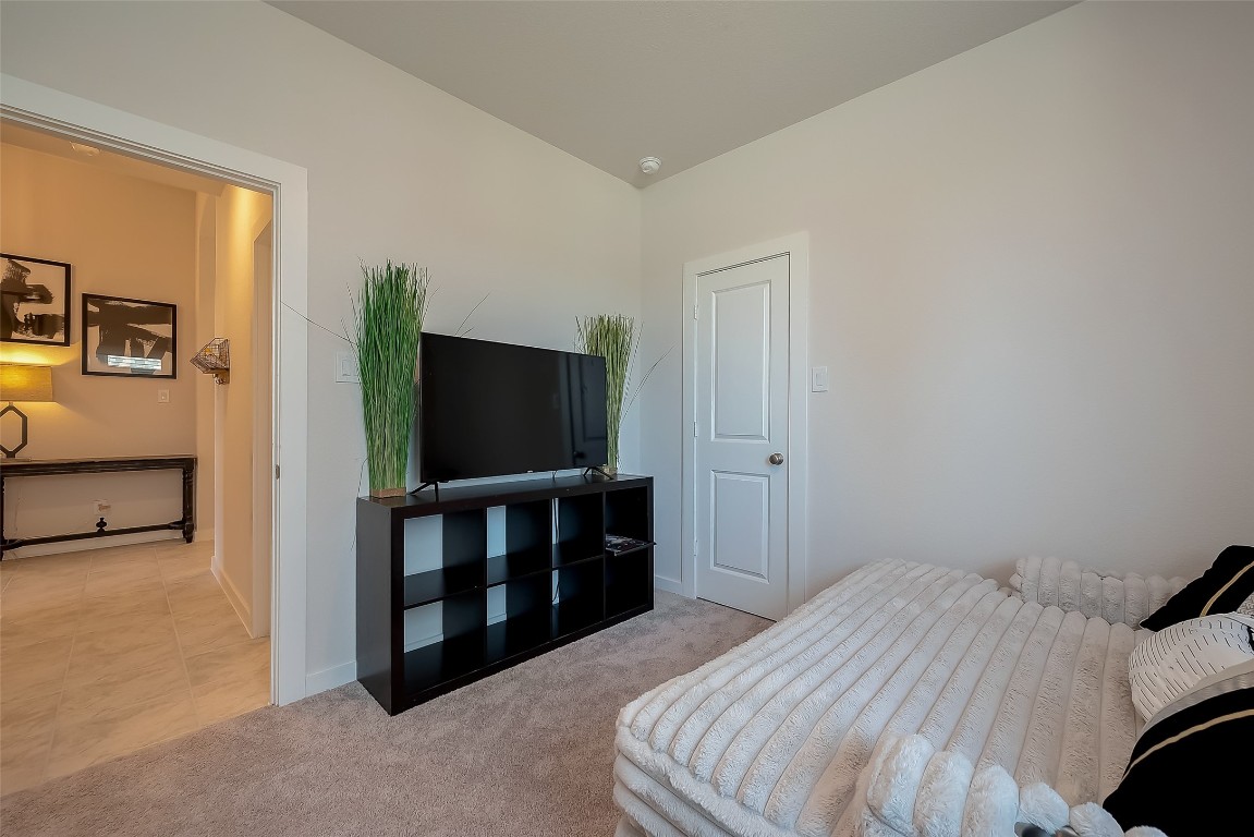 15714 Autumn Sun Conroe, TX 77302 - Photo 13 of 31 a bedroom with a bed and a flat screen tv