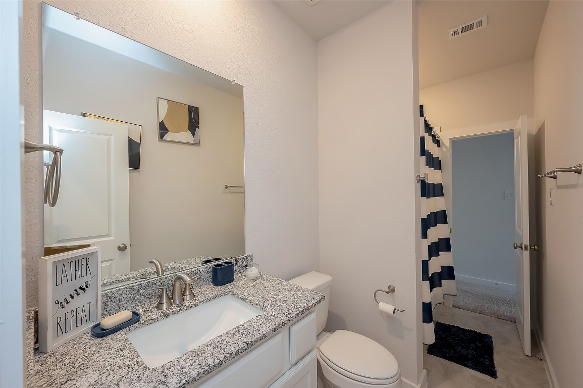 15714 Autumn Sun Conroe, TX 77302 - Photo 14 of 31 a bathroom with a granite countertop sink mirror vanity and toilet