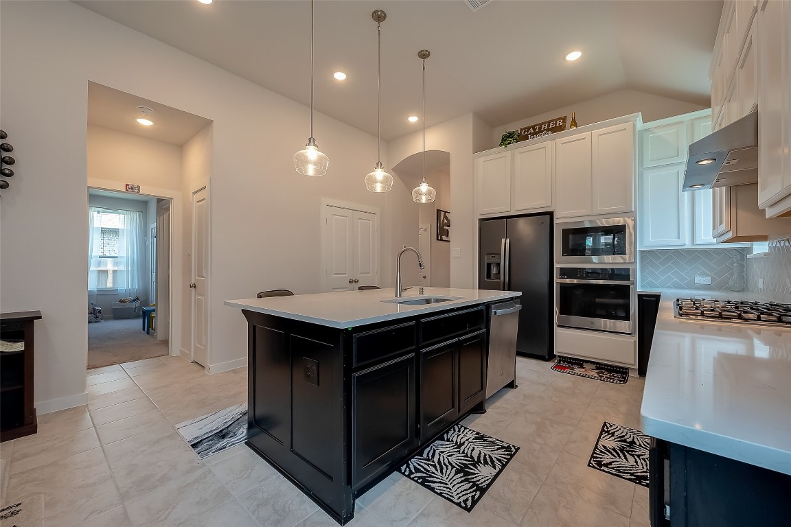15714 Autumn Sun Conroe, TX 77302 - Photo 18 of 31 a kitchen with stainless steel appliances a sink stove and refrigerator