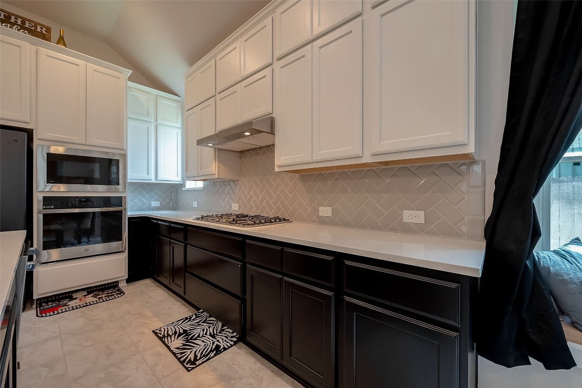 15714 Autumn Sun Conroe, TX 77302 - Photo 20 of 31 a kitchen with granite countertop a stove and a microwave
