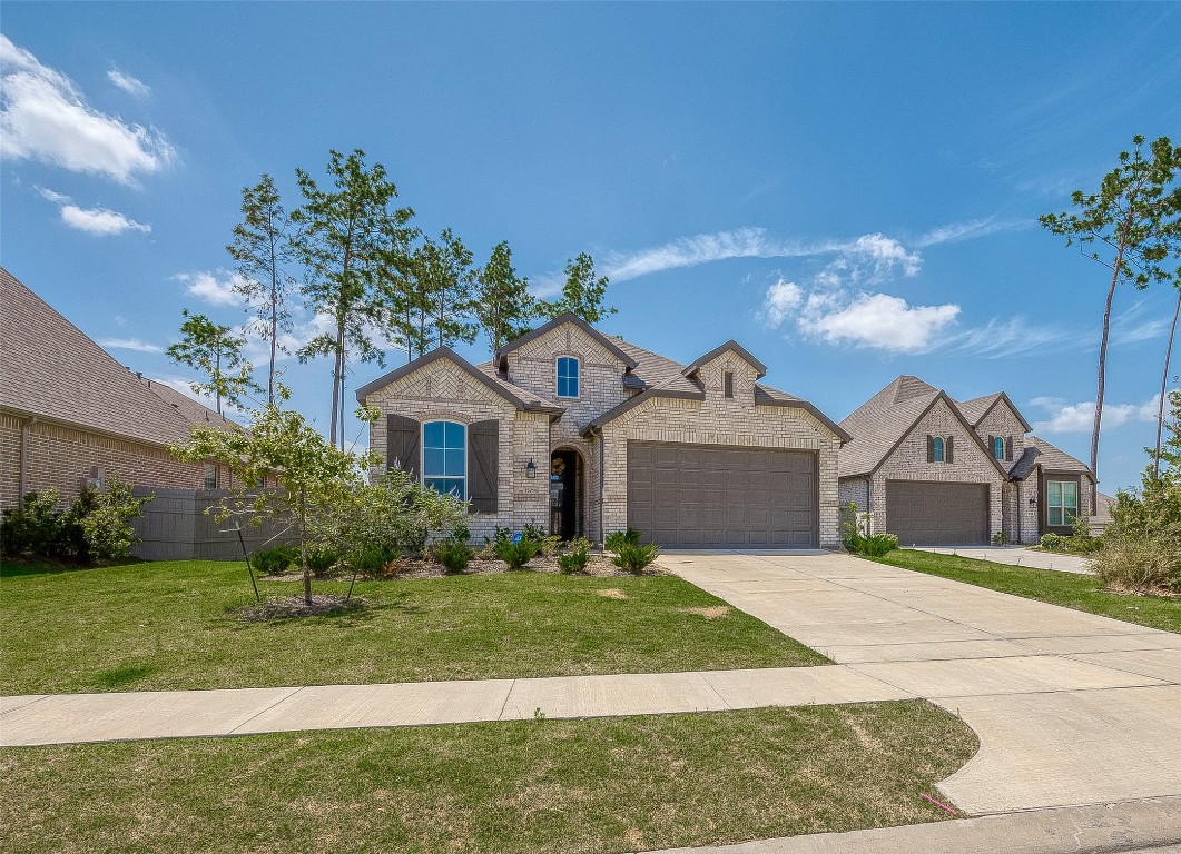 15714 Autumn Sun Conroe, TX 77302 - Photo 2 of 31 a front view of a house with a yard and garage
