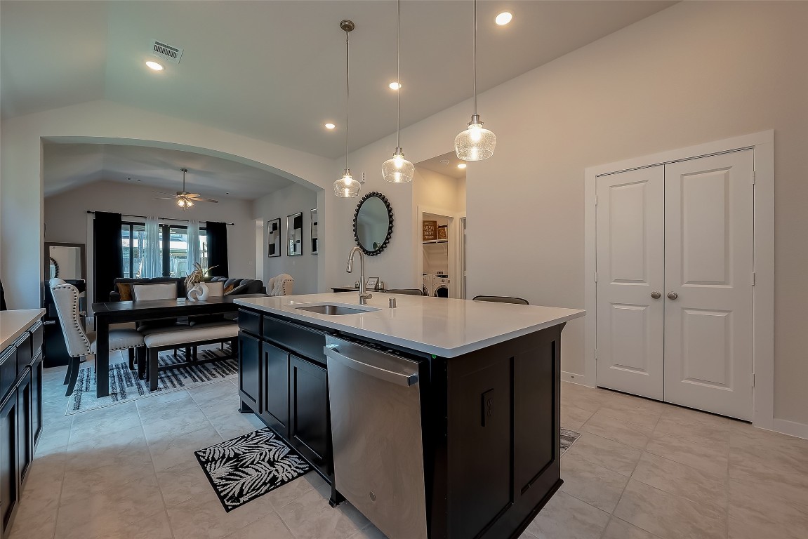 15714 Autumn Sun Conroe, TX 77302 - Photo 21 of 31 a large kitchen with kitchen island a sink a stove and a dining table with wooden floor