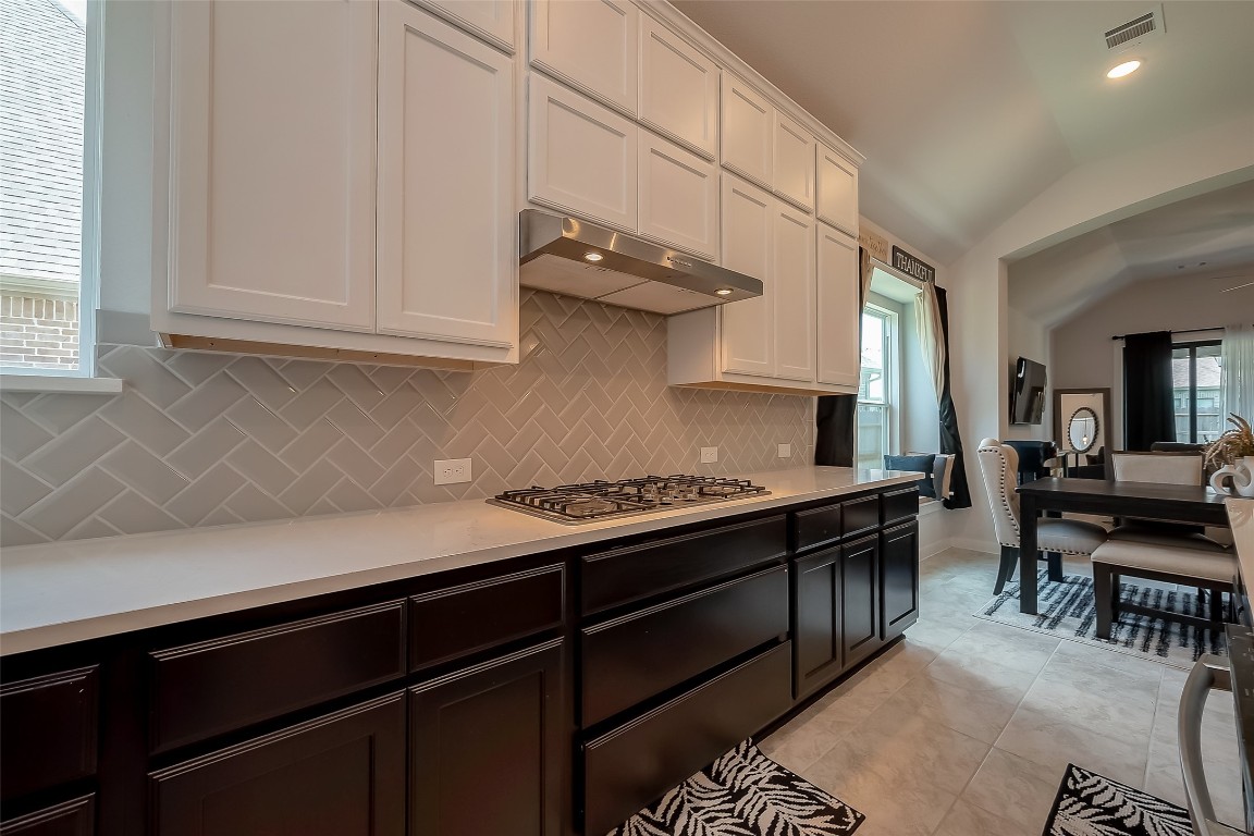 15714 Autumn Sun Conroe, TX 77302 - Photo 22 of 31 a kitchen with stainless steel appliances a stove and white cabinets