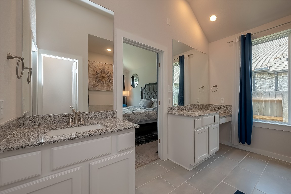 15714 Autumn Sun Conroe, TX 77302 - Photo 27 of 31 a spacious bathroom with a granite countertop sink and a mirror