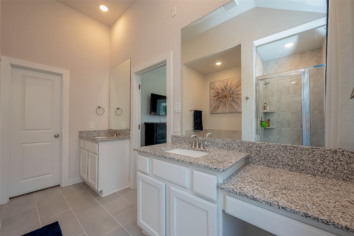 15714 Autumn Sun Conroe, TX 77302 - Photo 28 of 31 a bathroom with a granite countertop sink and a mirror