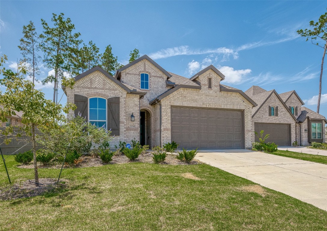 15714 Autumn Sun Conroe, TX 77302 - Photo 3 of 31 a front view of a house with a yard and garage