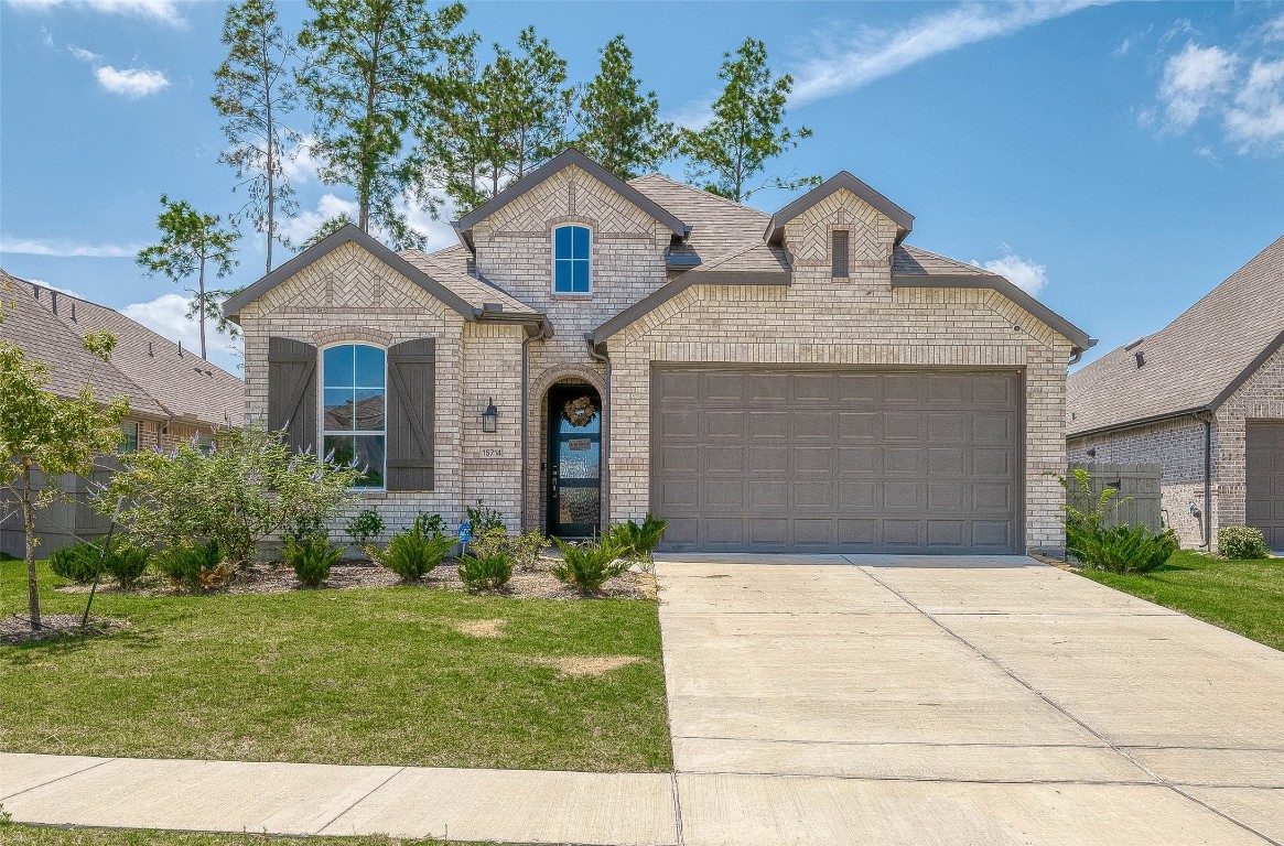 15714 Autumn Sun Conroe, TX 77302 - Photo 4 of 31 a front view of a house with a garden and plants
