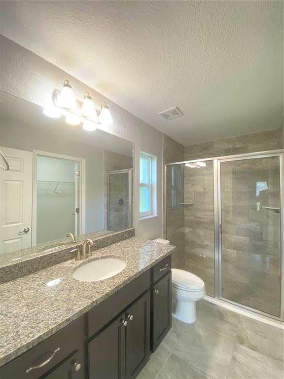 3200 Southwest 129th Loop Ocala, FL 34473 - Photo 15 of 29 a bathroom with a granite countertop sink a toilet a mirror and shower
