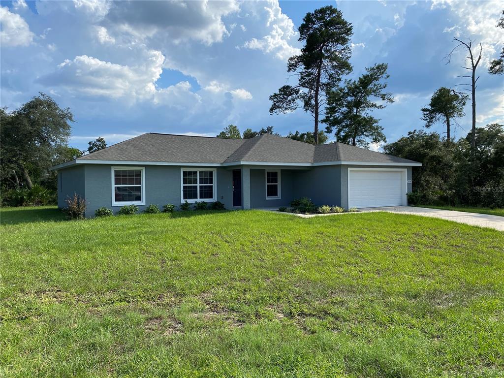 3200 Southwest 129th Loop Ocala, FL 34473 - Photo 2 of 29 a front view of a house with a garden
