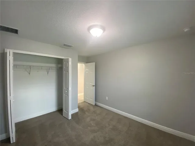 a bathroom with a granite countertop sink a toilet a mirror a bathtub and shower