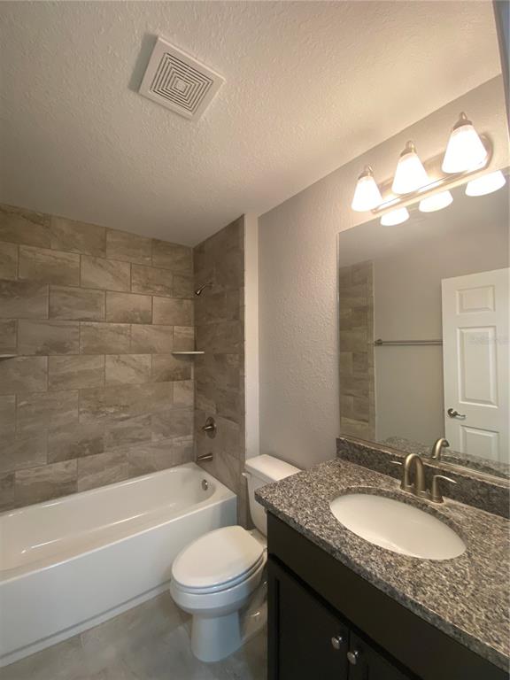 3200 Southwest 129th Loop Ocala, FL 34473 - Photo 22 of 29 a bathroom with a granite countertop sink a toilet a mirror a bathtub and shower