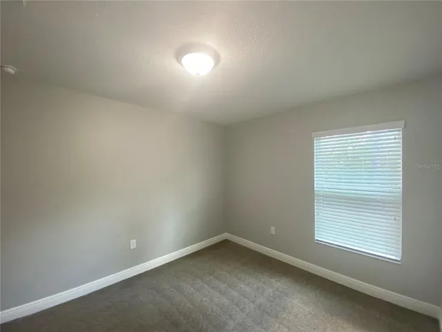 an empty room with closet and windows
