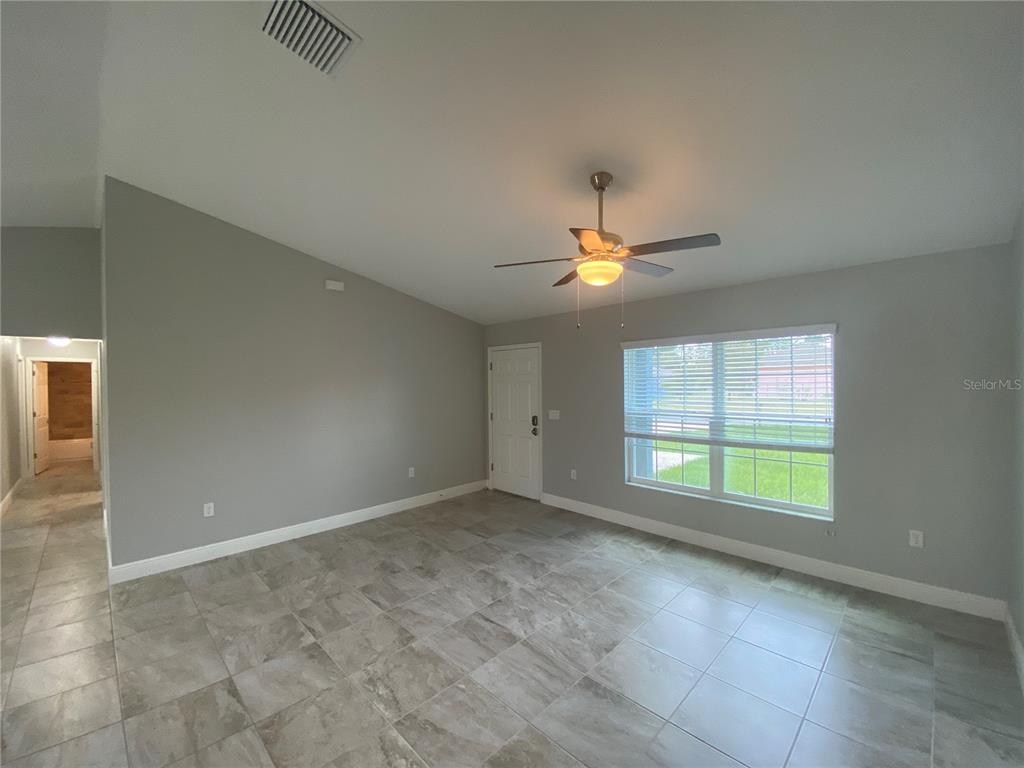 3200 Southwest 129th Loop Ocala, FL 34473 - Photo 6 of 29 an empty room with chandelier fan and windows