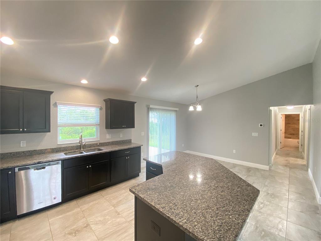 3200 Southwest 129th Loop Ocala, FL 34473 - Photo 7 of 29 a large kitchen with granite countertop counter top space a sink and cabinets