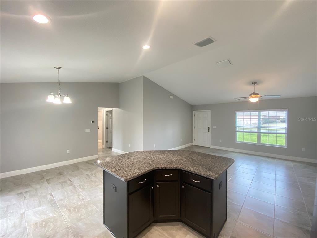 3200 Southwest 129th Loop Ocala, FL 34473 - Photo 9 of 29 an open kitchen with granite countertop a sink and a stove