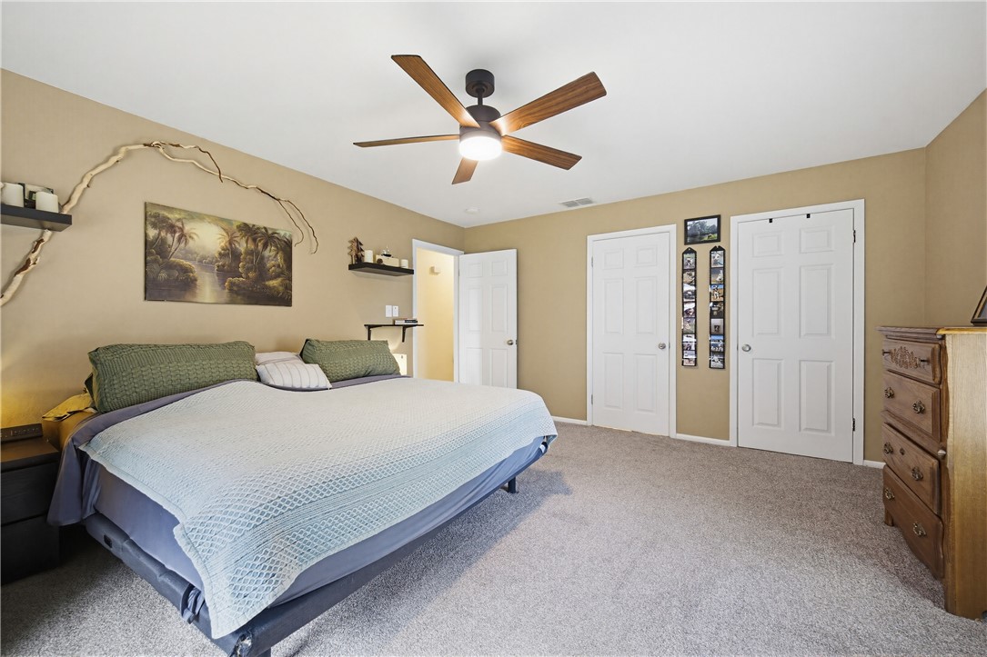 234 East Trant Road Kingsville, TX 78363 - Photo 14 of 32 a bedroom with a large bed and a ceiling fan