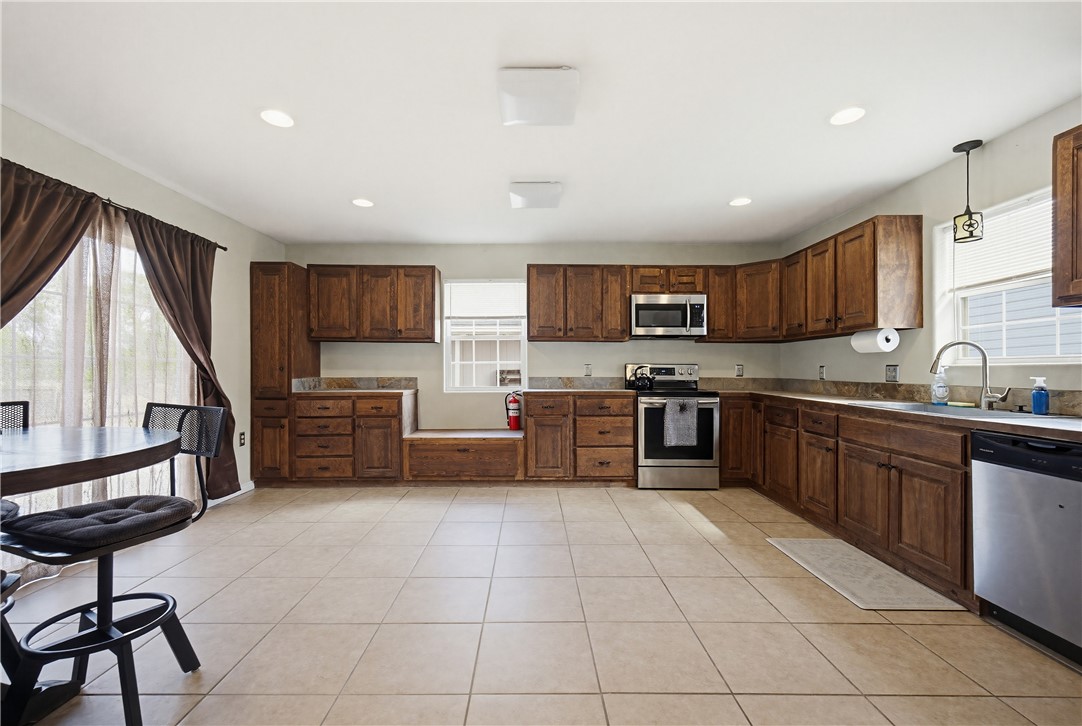 234 East Trant Road Kingsville, TX 78363 - Photo 10 of 32 a kitchen with stainless steel appliances granite countertop a stove top oven a sink dishwasher a refrigerator and a microwave